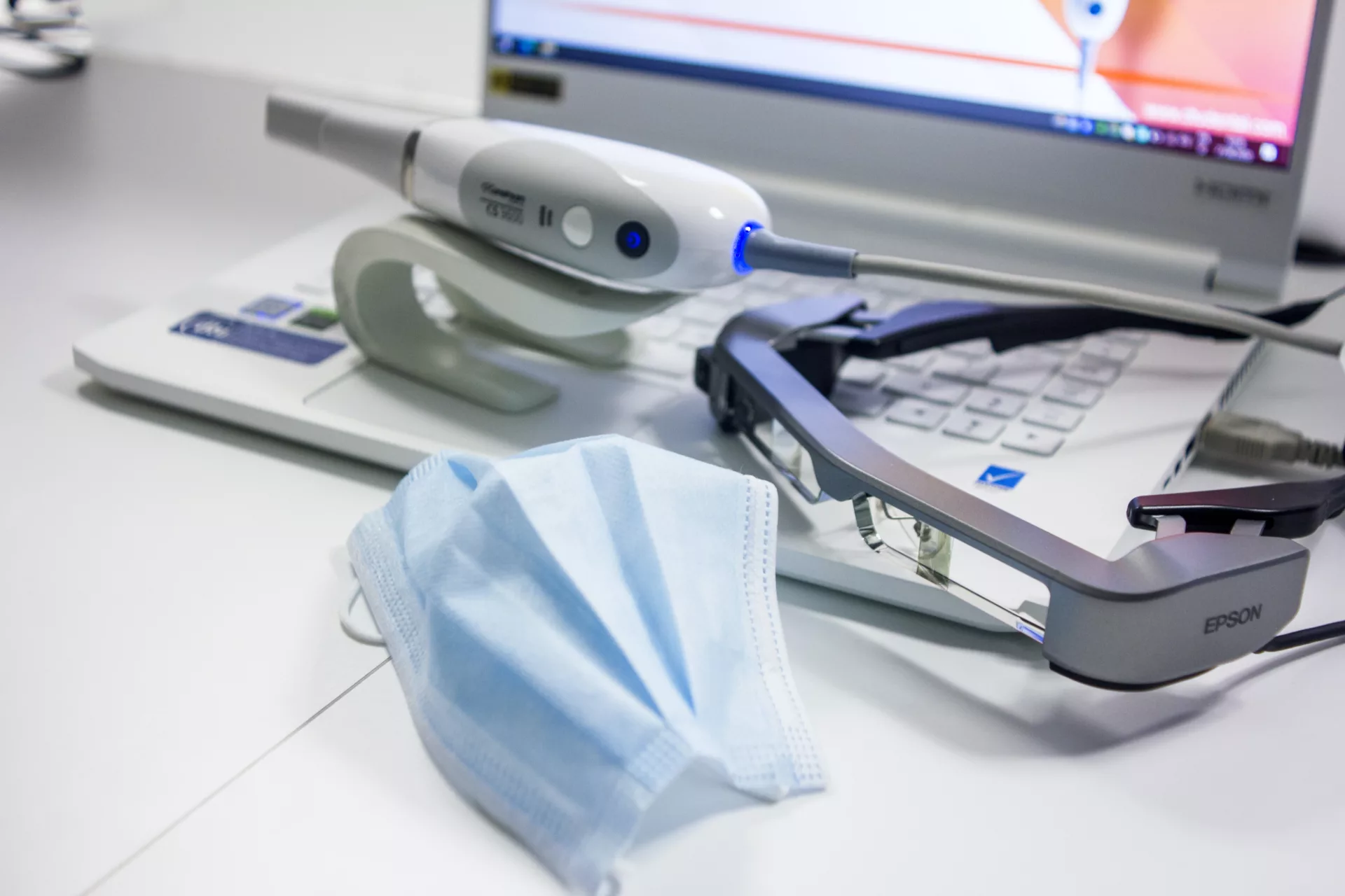 dental tools sitting on top of an opened laptop