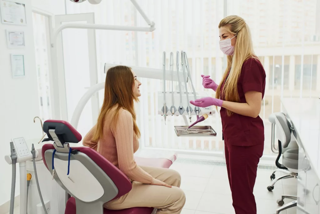 dental hygienist talking to her patient sitting in the dentist chair